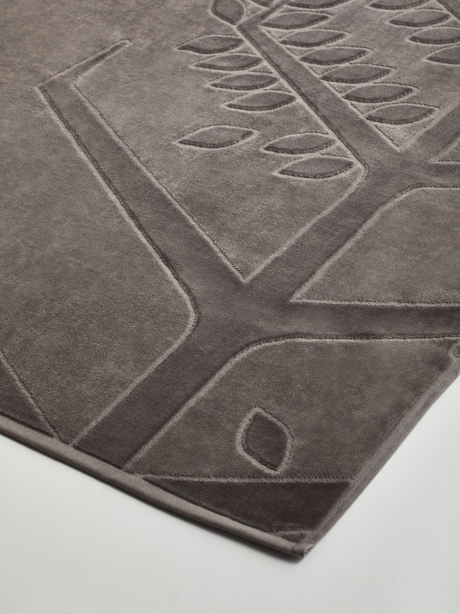 Close-up of a "Californian Driftwood" beach towel with a textured and embossed Four Seasons logo design. - {{Californian Driftwood}}