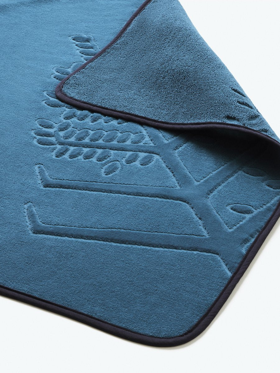 Close-up detail of a "Underwater Blue" hooded baby towel with a textured, embroidered Four Seasons logo. - {{Underwater Blue / Mountain Grey}}