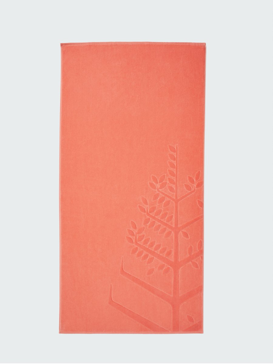 A 'Red Sea Coral' beach towel with the Four Seasons logo embossed on it. - {{Red Sea Coral}}