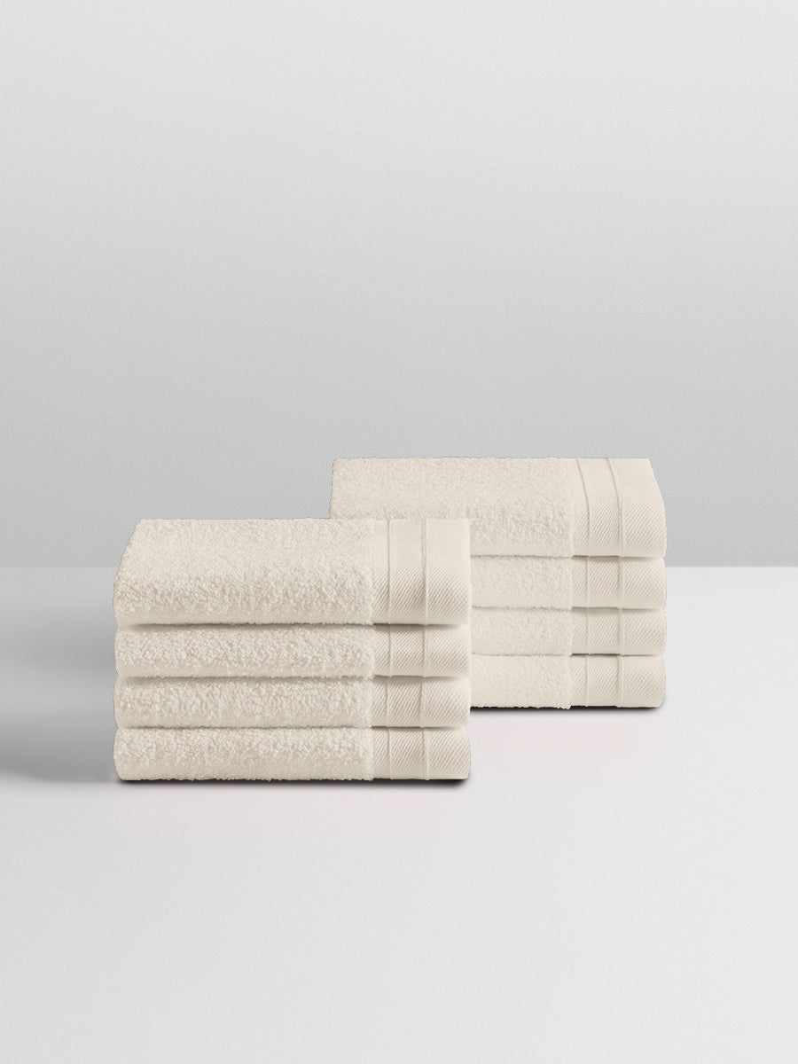 A stack of eight soft, “Balinese Pearl” colored clothes neatly folded on a white surface. - {{Balinese Pearl}}