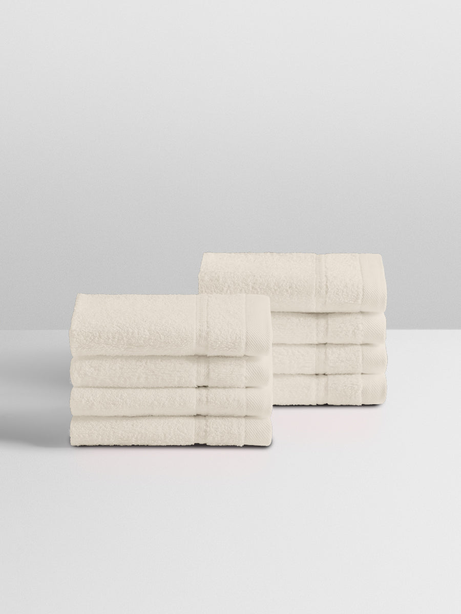 A stack of eight soft, “Balinese Pearl” colored clothes neatly folded on a white surface. - {{Balinese Pearl}}