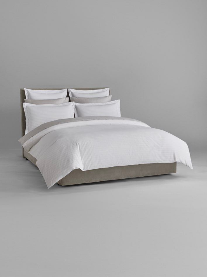 Luxury bed dressed with Signature White/Turkish Silver sheets and duvet. - {{Signature White/Turkish Silver}}