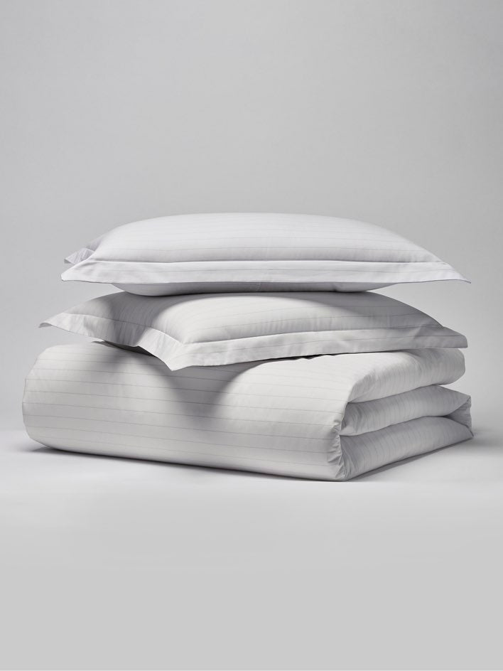 Two pillows with a subtle striped design in Signature White/Turkish Silver colors. - {{Signature White/Turkish Silver}}
