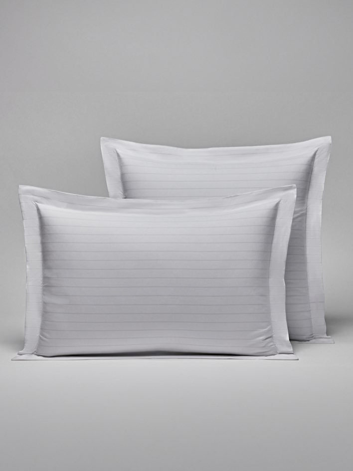 Two pillows with a subtle striped design in Signature White/Turkish Silver colors. - {{Signature White/Turkish Silver}}