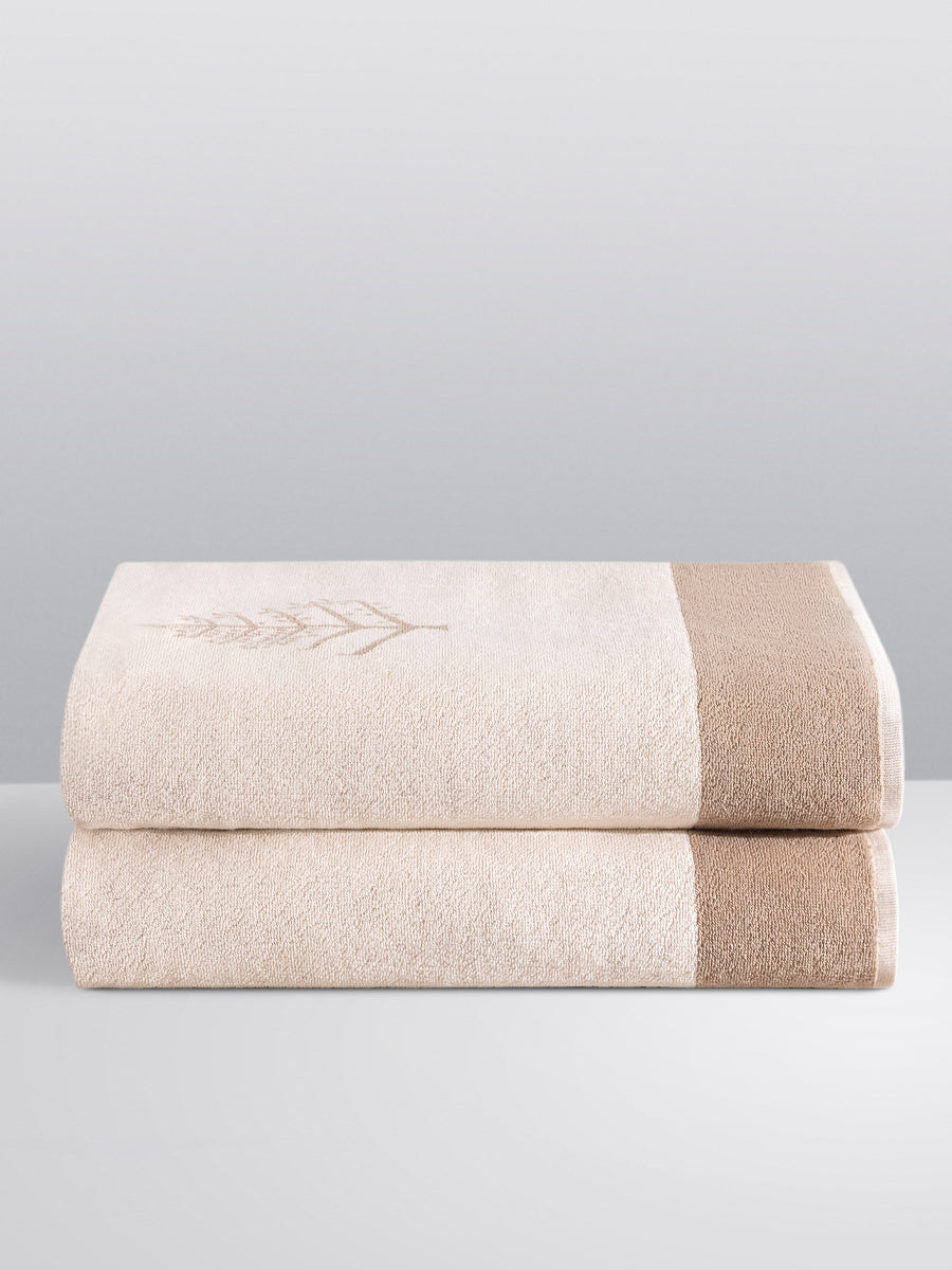 Two folded Resort Towels in a "Californian Driftwood" color, featuring an embroidered Four Seasons logo. The towels are stacked on a white surface. - {{Californian Driftwood}}