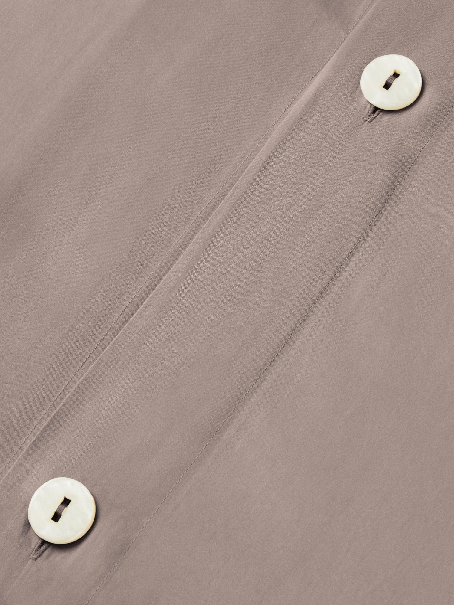 Close-up of duvet cover button closure in Moroccan Sand color, showing two mother-of-pearl buttons and a diagonal placket seam. {{Moroccan Sand}}