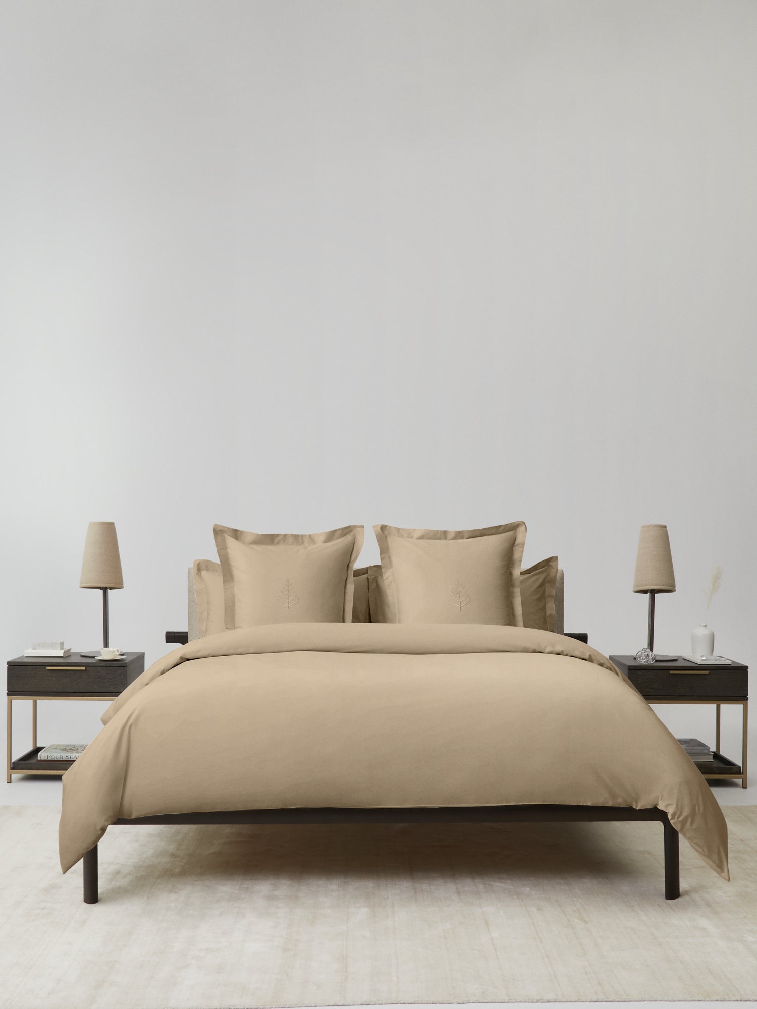Bed dressed in an Egyptian Camel duvet cover set; bordered shams with tone-on-tone logo store; minimalist nightstands and lamps.{{Egyptian Camel}}