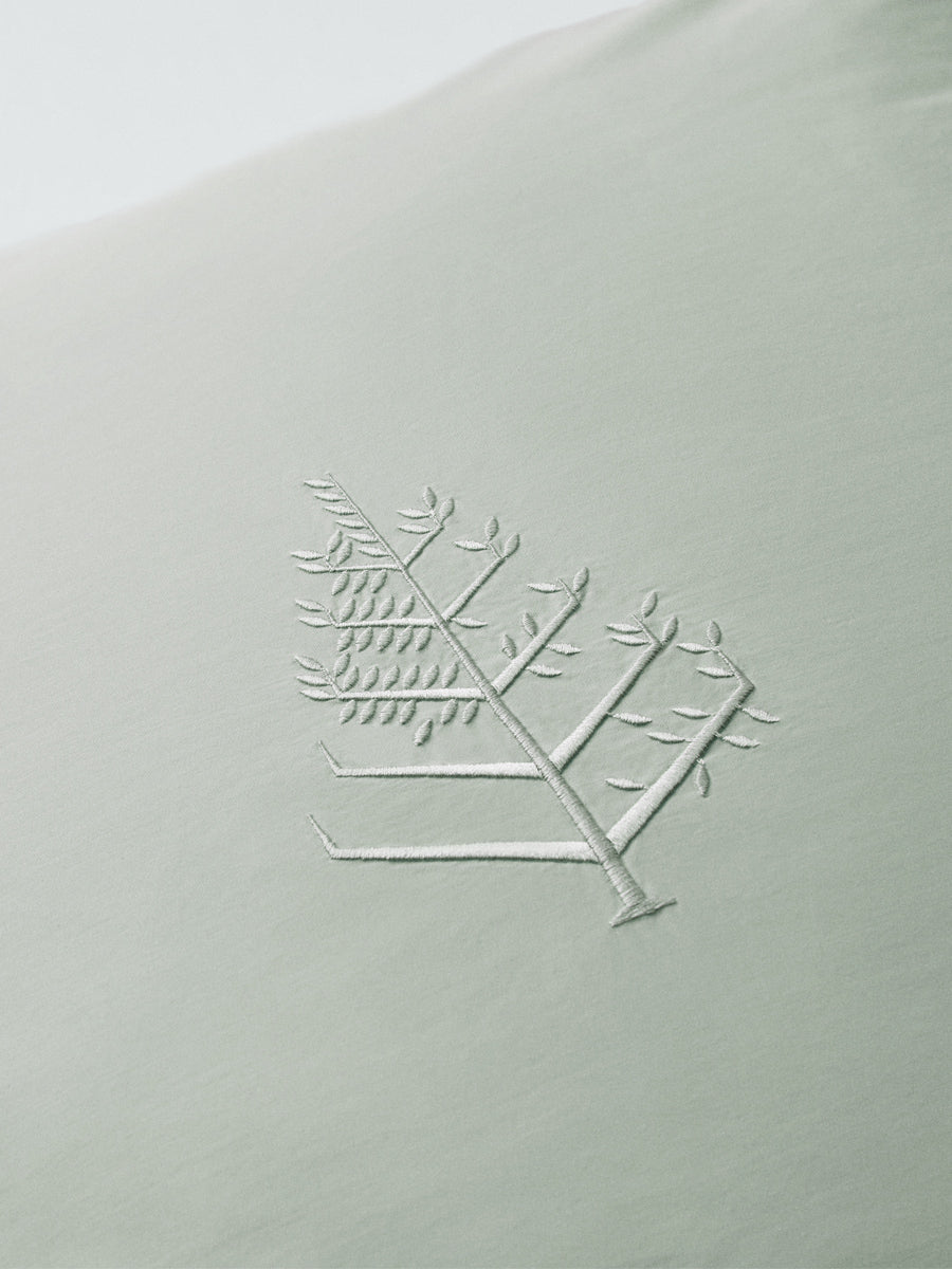 Close-up of Florentine Sage Euro sham with tone-on-tone logo store embroidery. {{Florentine Sage}}
