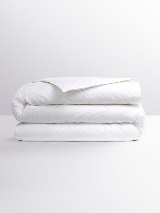 White duvet folded into three parts. Its design suggests a versatile duvet, suitable for various temperatures.