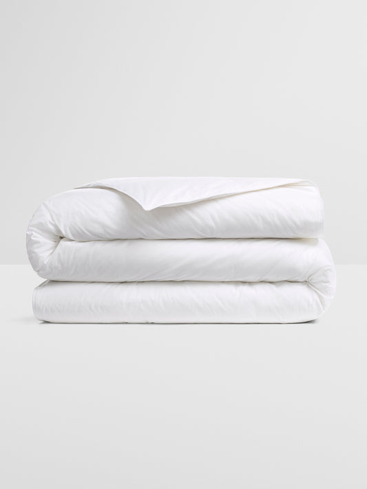 All Seasons Duvet — premium white down insert, neatly folded on a neutral surface for year-round comfort. {{Balinese Pearl}}