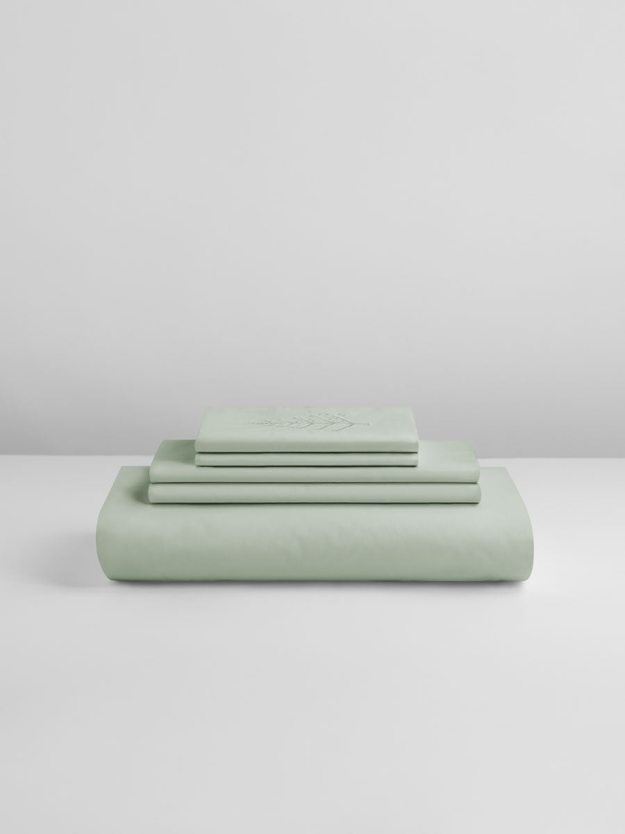 Florentine Sage duvet cover set stacked: folded duvet and shams; top piece with tone-on-tone logo store embroidery. {{Florentine Sage}}