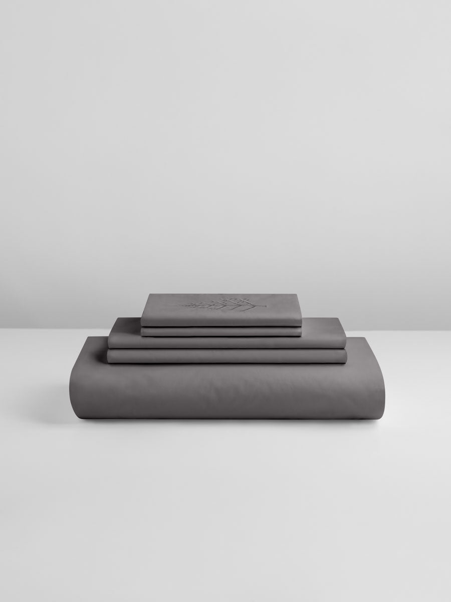 Hampshire Charcoal duvet cover set stacked: folded duvet and shams; top piece with tone-on-tone logo store embroidery {{Hampshire Charcoal}}