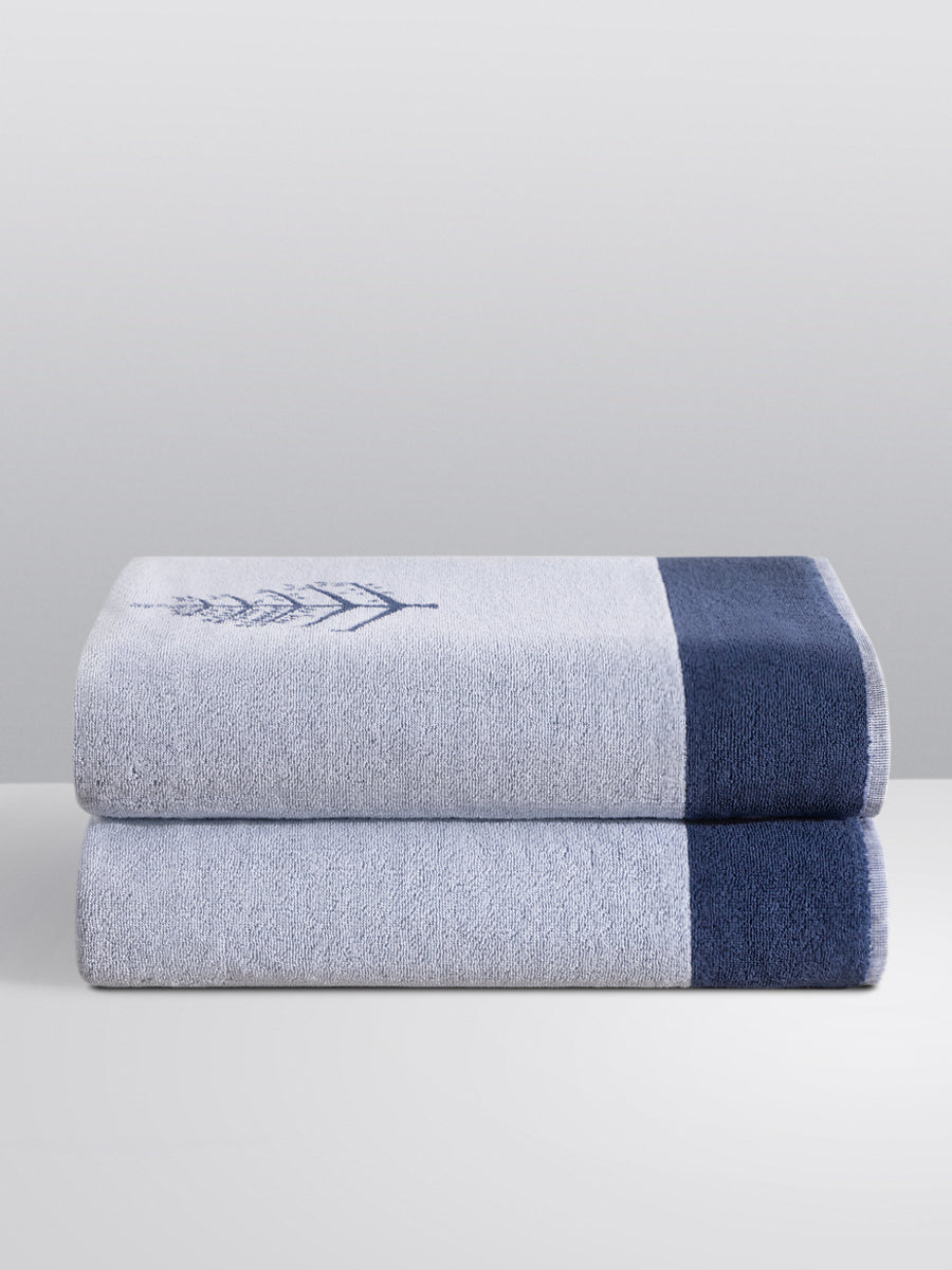 Two folded Resort Towels in a "Maldivian Atoll" color, featuring an embroidered Four Seasons logo. The towels are stacked on a white surface. - {{Maldivian Atoll}}