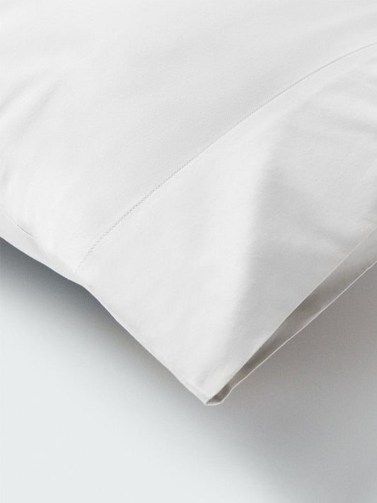 Part of a pillow with a pillowcase in Signature White color. - {{Signature White}}
