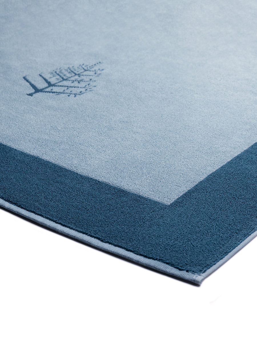 Close-up of a "Polynesian Lagoon" Resort Towel with a subtle embroidered Four Seasons logo. The towel features a darker border. - {{Polynesian Lagoon}}
