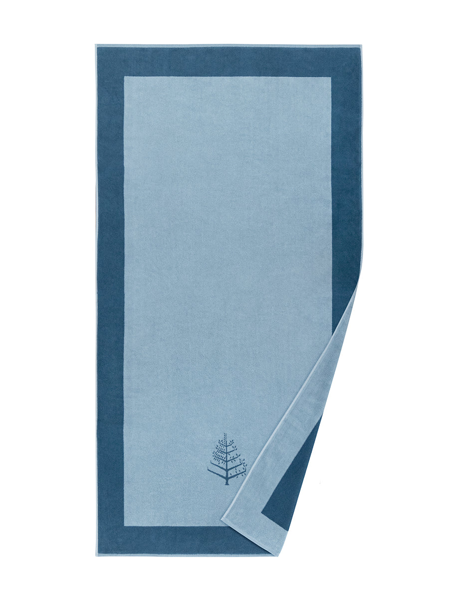 A "Maldivian Atoll" Resort Towel with a subtle embroidered Four Seasons logo. The towel features a darker border and is folded on a white background. - {{Polynesian Lagoon}}