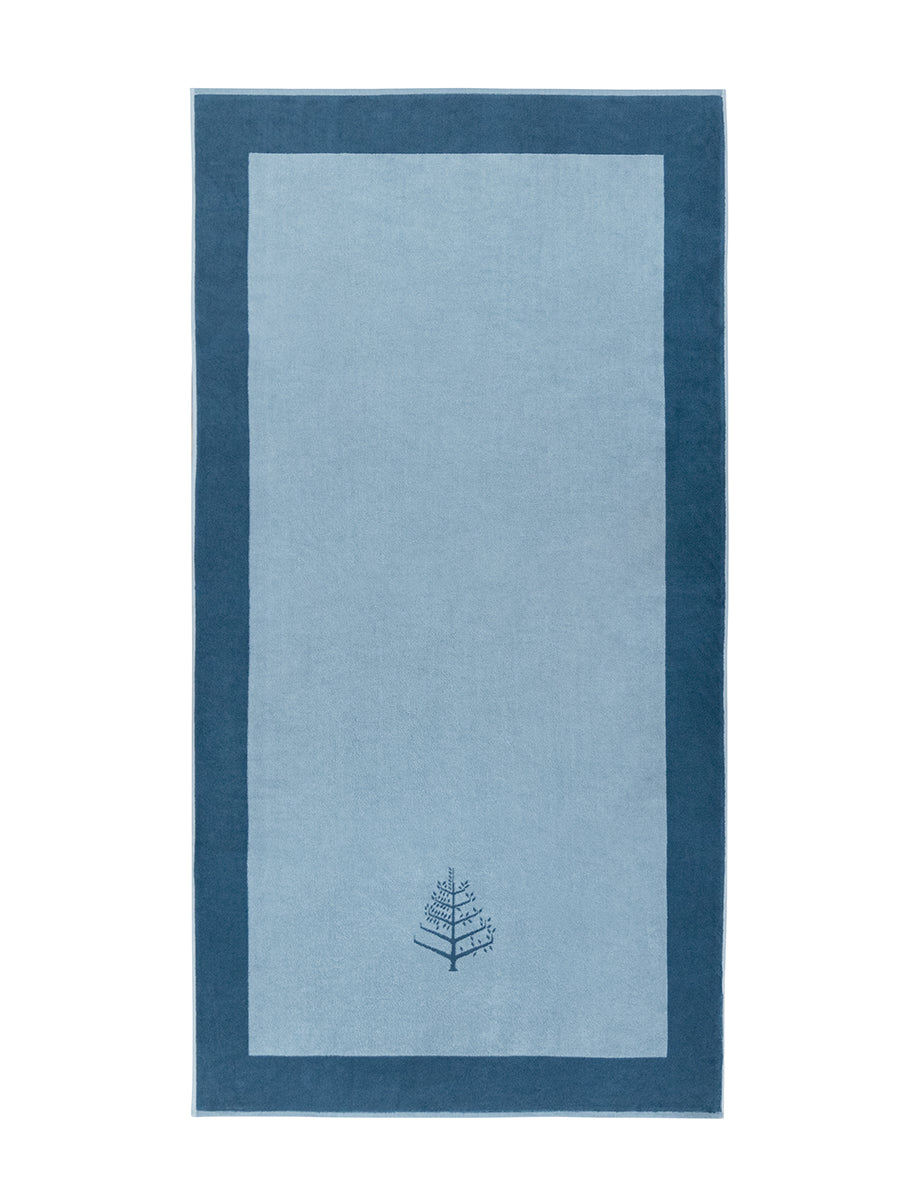 A "Polynesian Lagoon" Resort Towel with a subtle embroidered Four Seasons logo. The towel features a darker border and is folded on a white background. - {{Polynesian Lagoon}}