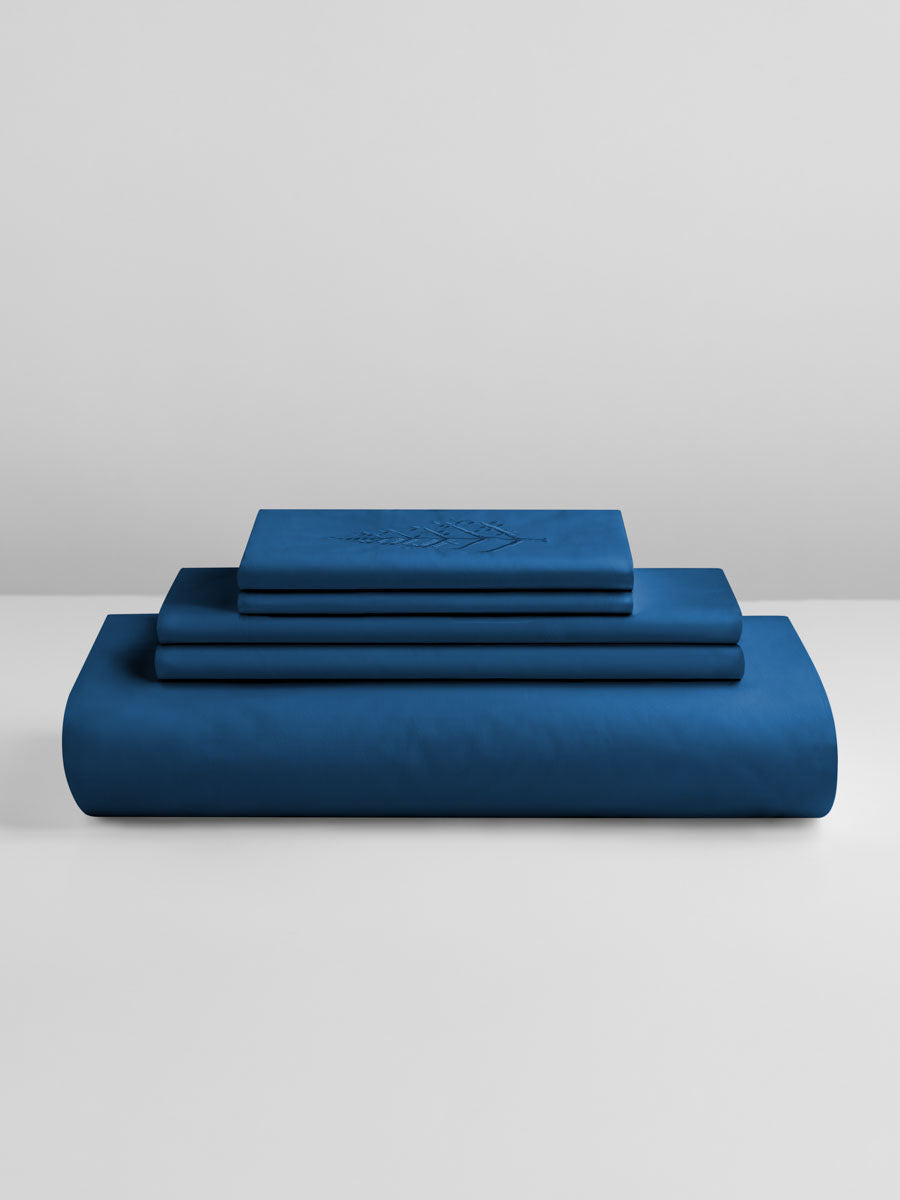 Riviera Navy duvet cover set stacked: folded duvet and shams; top piece with tone-on-tone logo store embroidery. {{Riviera Navy}}