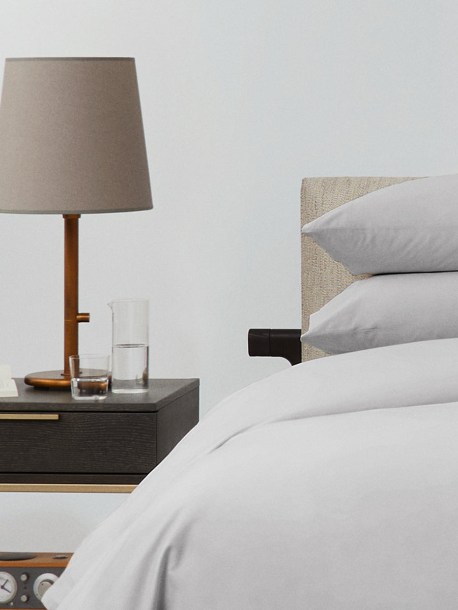 Bed dressed with a duvet in Turkish Silver color and two matching pillows. - {{Turkish Silver}}