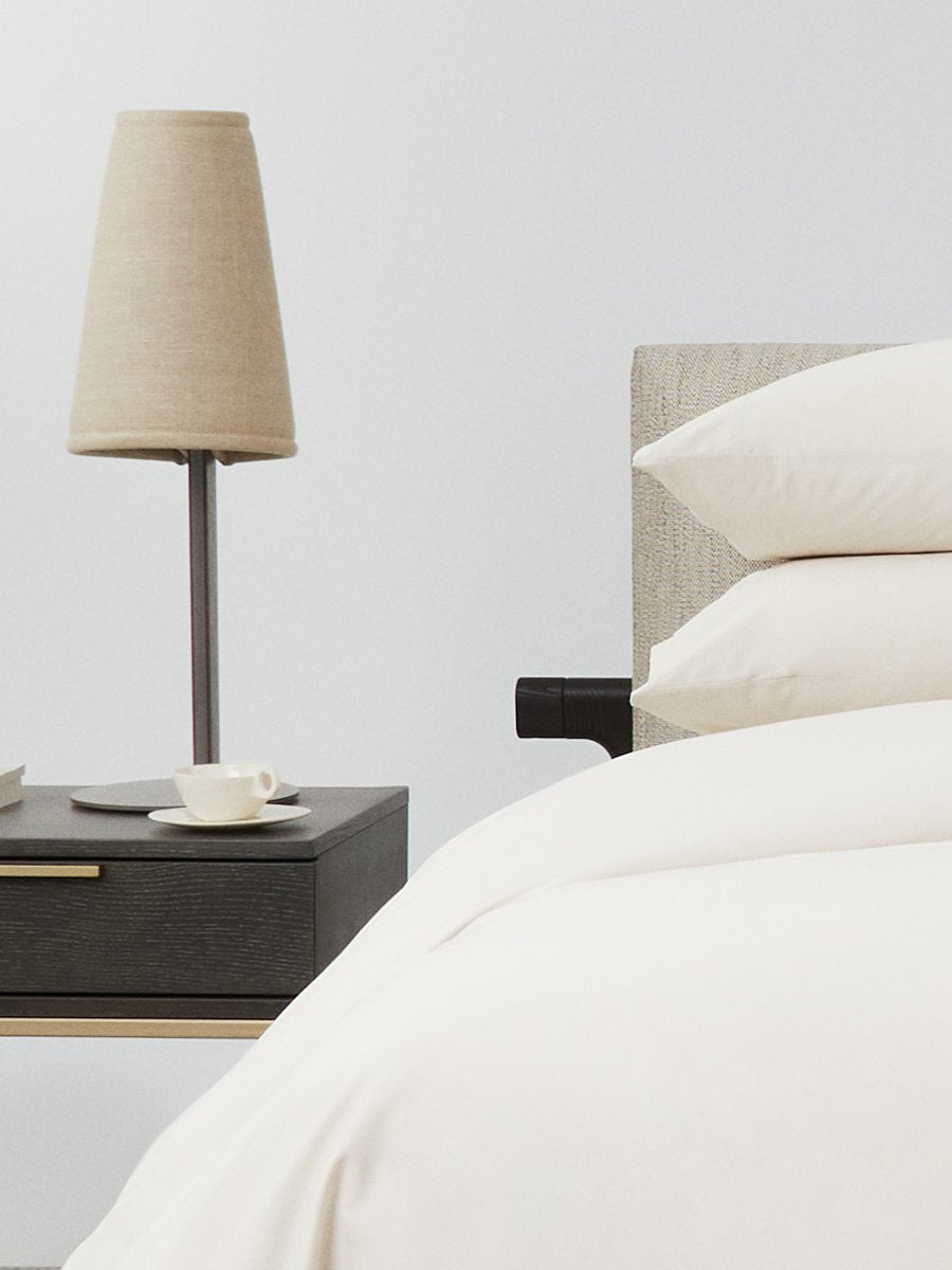 Bed dressed with a duvet in Balinese Pearl color and two matching pillows. - {{Balinese Pearl}}