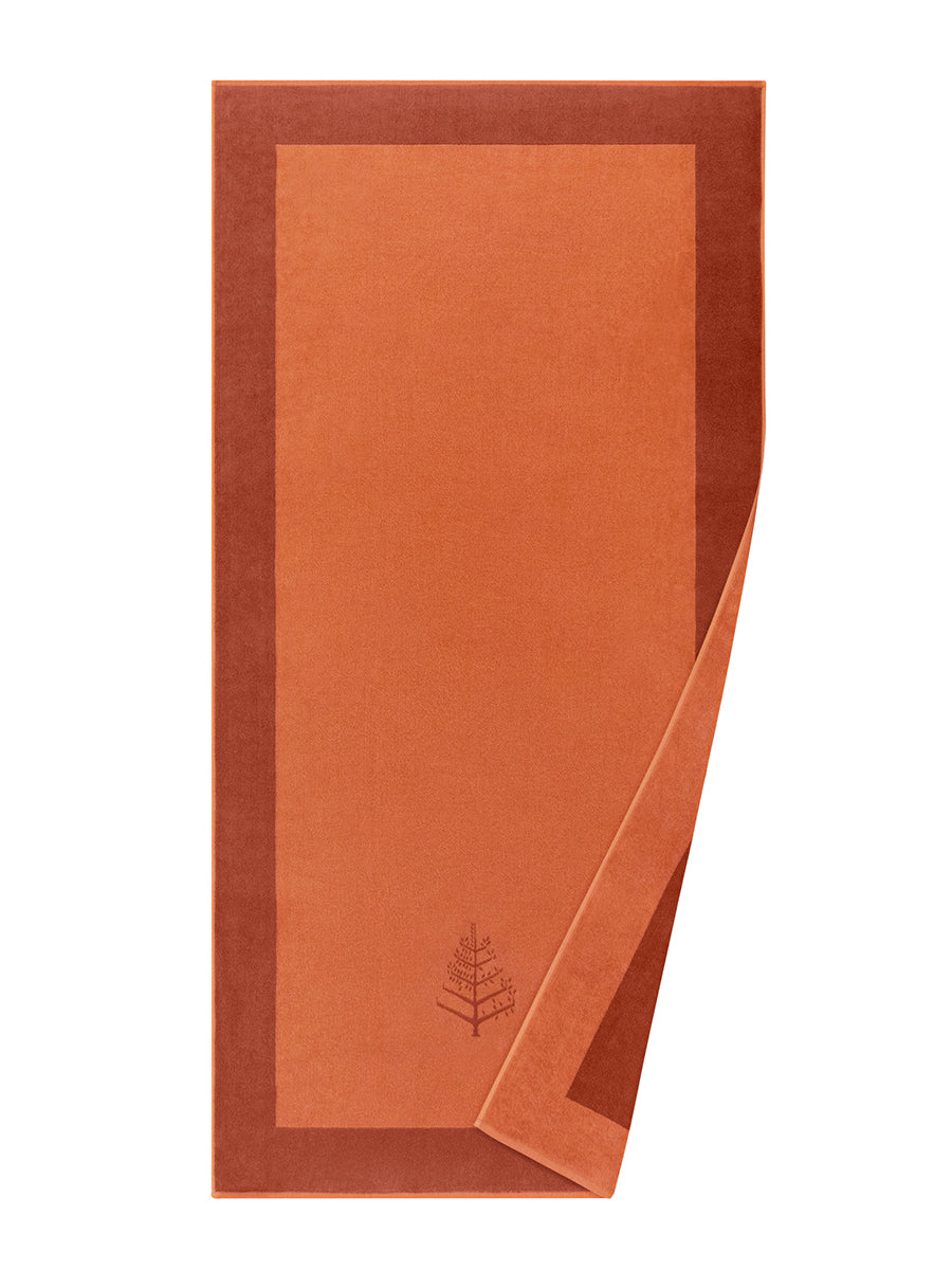 A "Sicilian Dawn" Resort Towel with a subtle embroidered Four Seasons logo. The towel features a darker border and is folded on a white background. - {{Sicilian Dawn}}