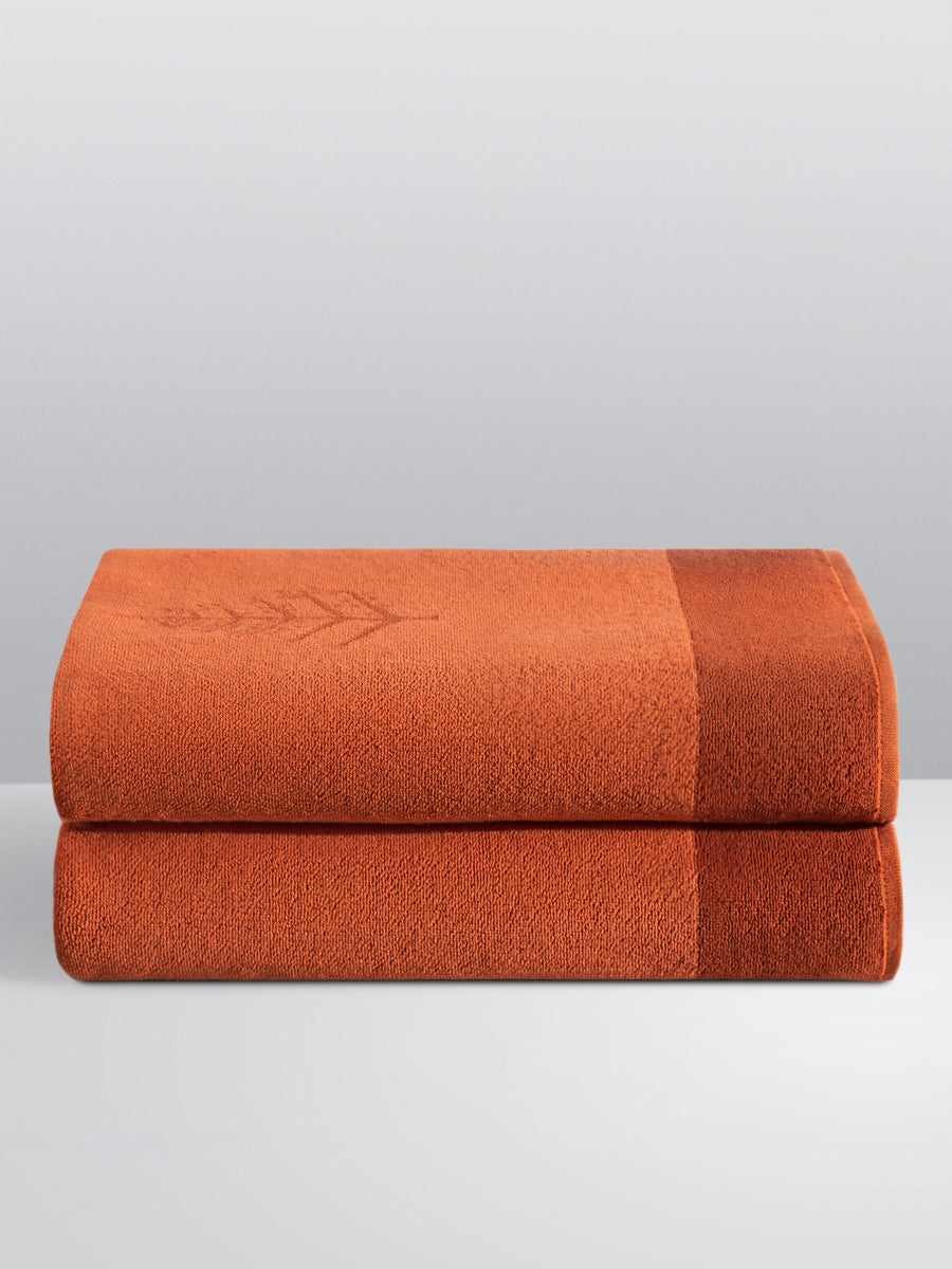 Two folded Resort Towels in a "Sicilian Dawn" color, featuring an embroidered Four Seasons logo. The towels are stacked on a white surface. - {{Sicilian Dawn}}