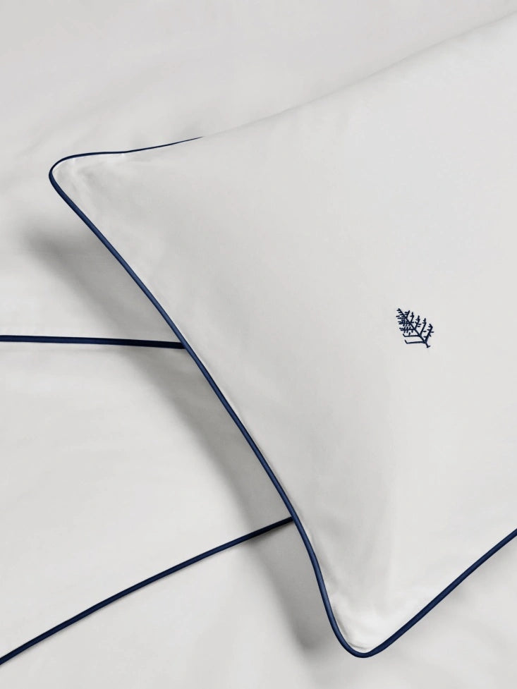 Close-up of a Sycamore Signature White pillow case border corner with a Four Seasons Logo. {{Signature White}}
