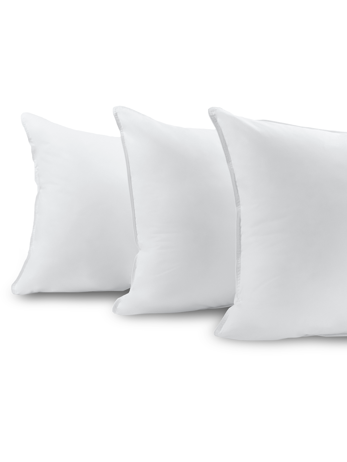 Three fluffy white pillows, stacked one on top of the other.