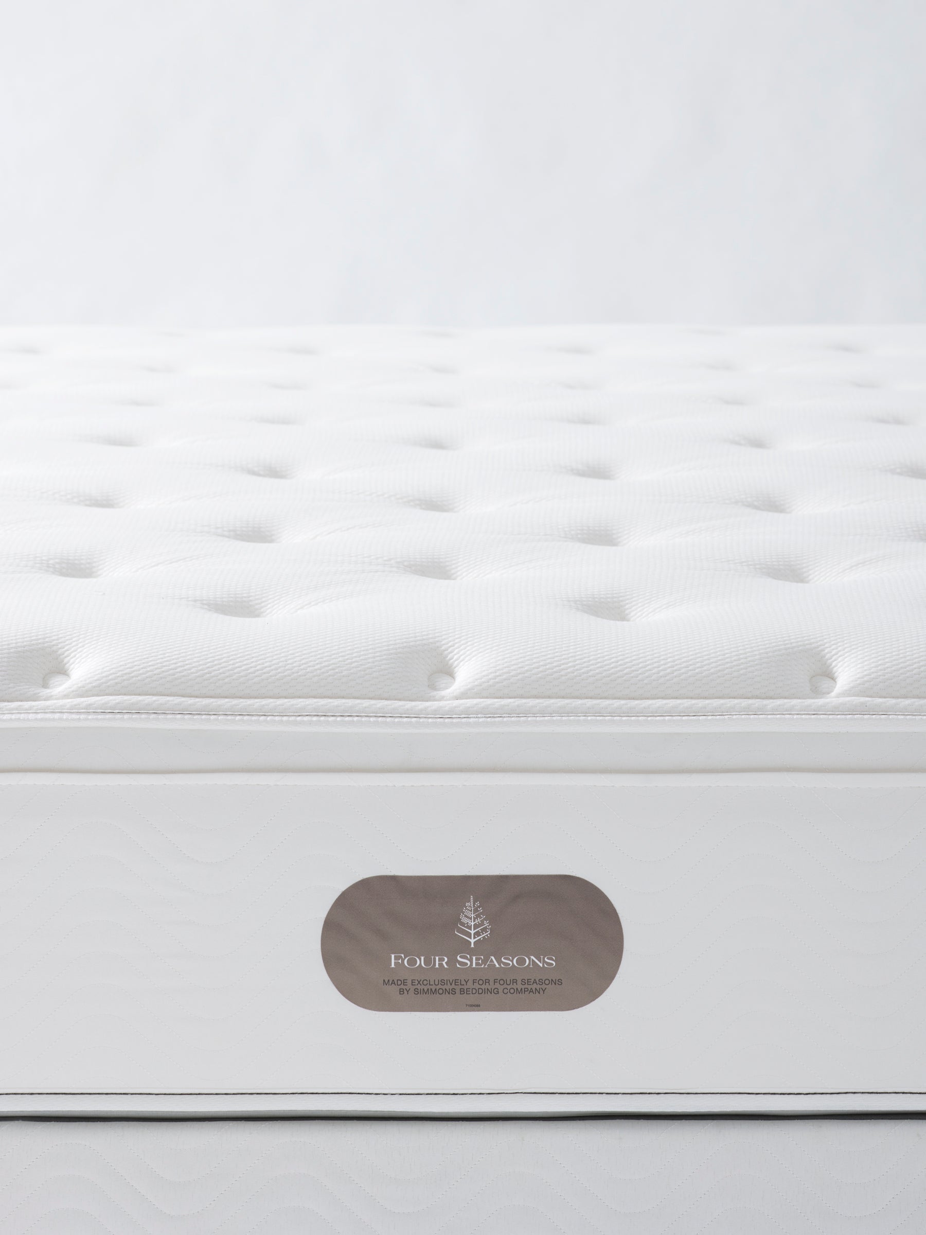 White mattress with quilted top and Four Seasons logo.