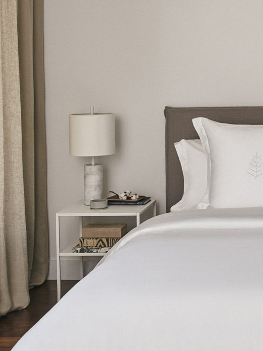 Luxurious white down duvet folded neatly on a bed, showcasing its premium quality and craftsmanship.