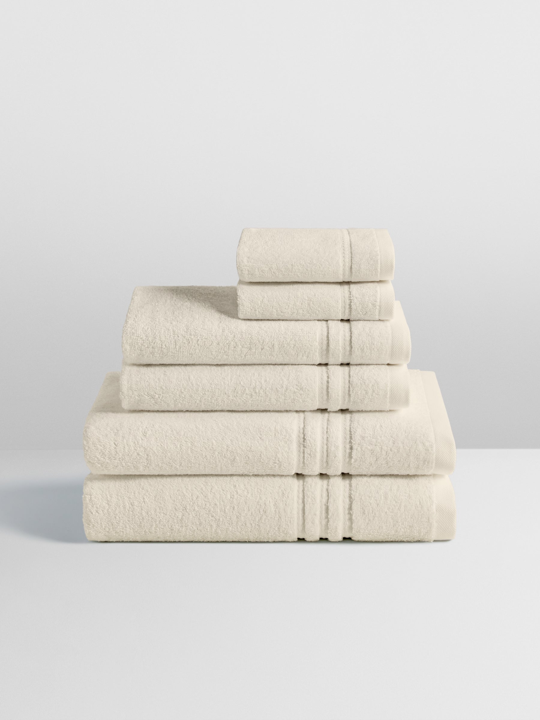 6-piece colored towel set in Balinese Pear, finished with a patterned dobby border. - {{Balinese Pearl}}