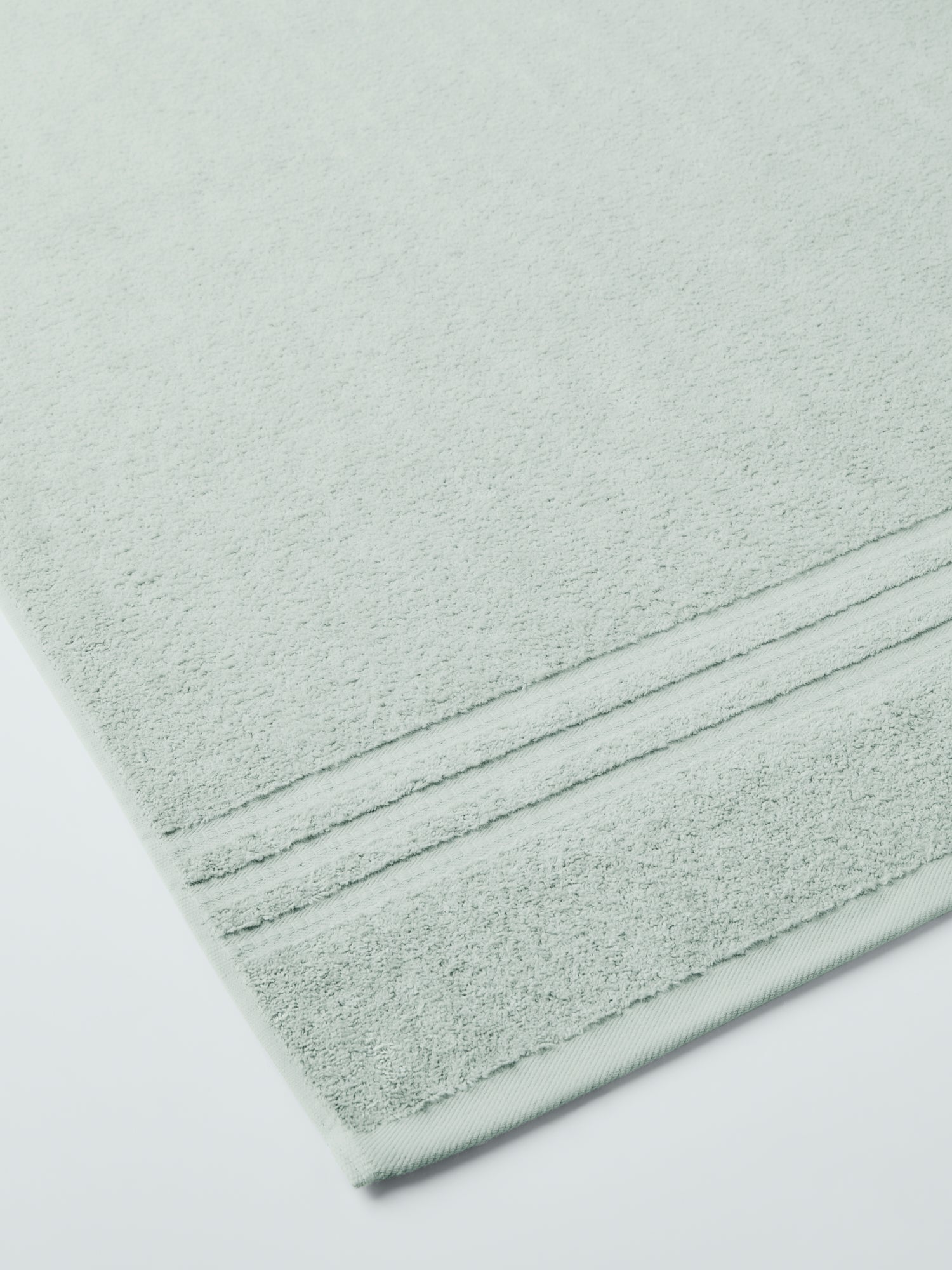plush, folded bath sheets in a warm, inviting "Florentine Sage" color. The towels have a thick, textured weave and subtle stripes - {{Florentine Sage}}