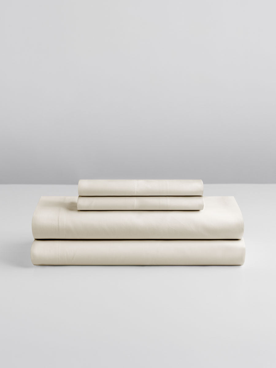 A set of Signature Whitel-colored sheets, folded into perfect rectangles and stacked on a flat surface.