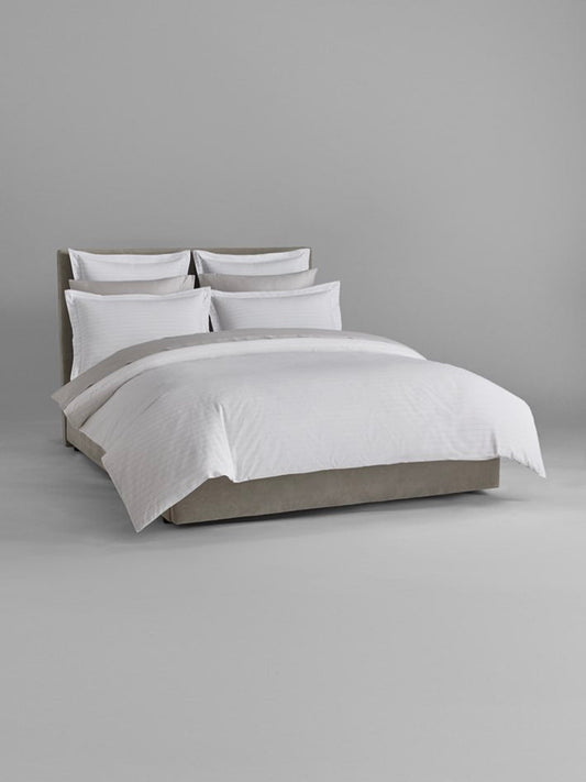 Luxury bed dressed with Signature White/Turkish Silver sheets and duvet. - {{Signature White/Turkish Silver}}