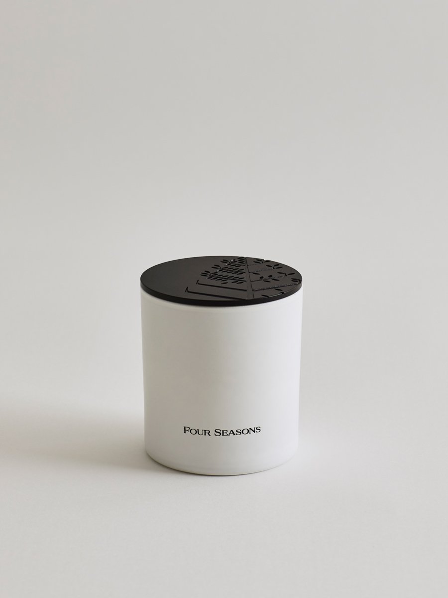 Exclusive votive candle with an elegant white jar and a black lid.