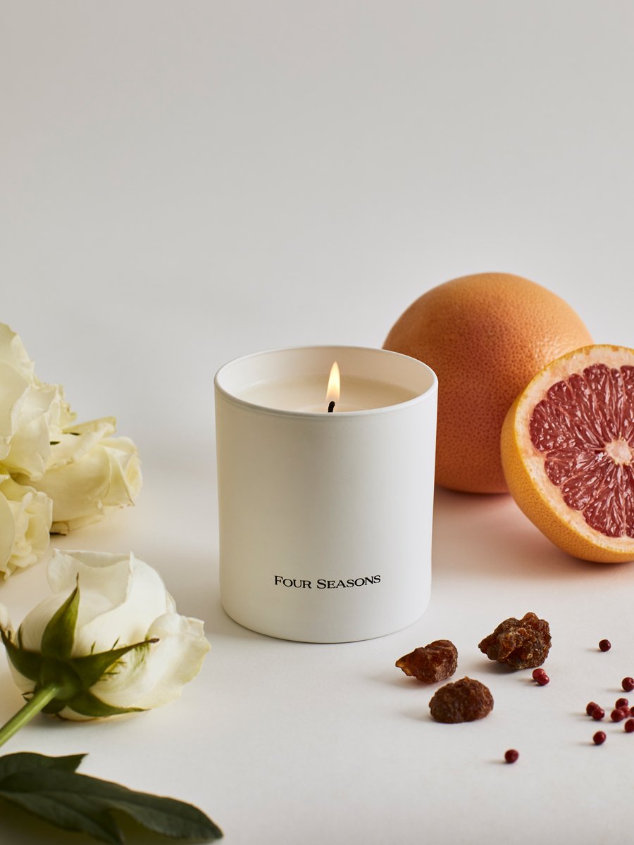 A lit Four Seasons candle from the Candle Set, designed with elements representing its key notes.