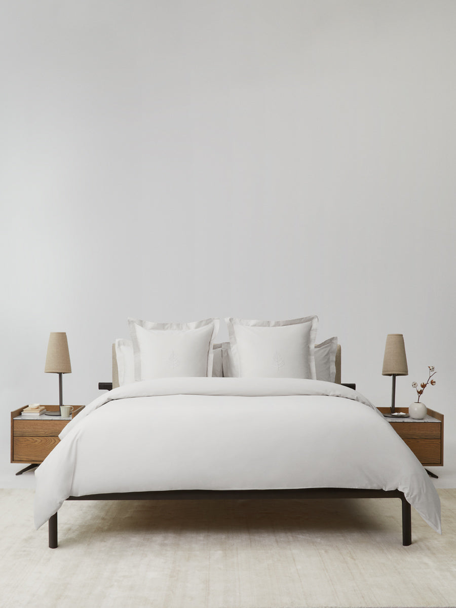 Bed with a white duvet and several pillows, creating a cozy atmosphere.