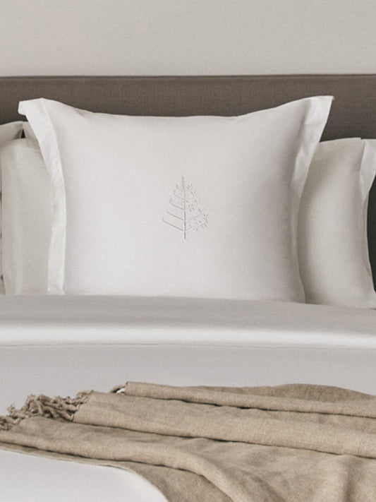 Elegant pair of square pillows in Signature White color resting on a luxurious bed.