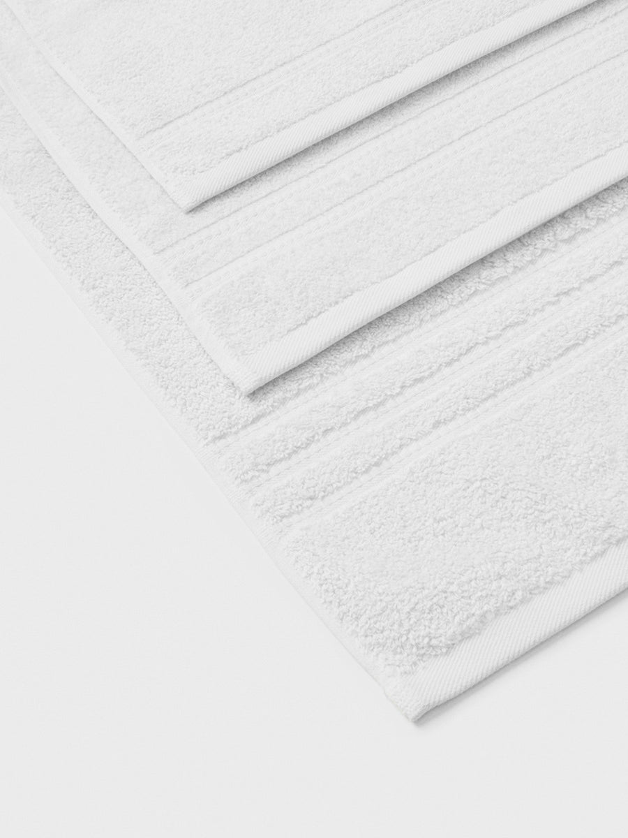 towel set in Signature White, finished with a patterned dobby border. - {{Signature White}}