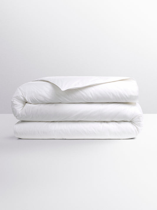 White duvet folded into three parts. Its design suggests a versatile duvet, suitable for various temperatures.