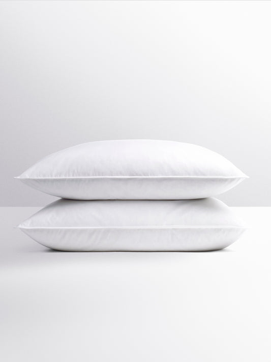 Pair of fluffy white pillows, stacked on top of each other. -{{Signature White}}