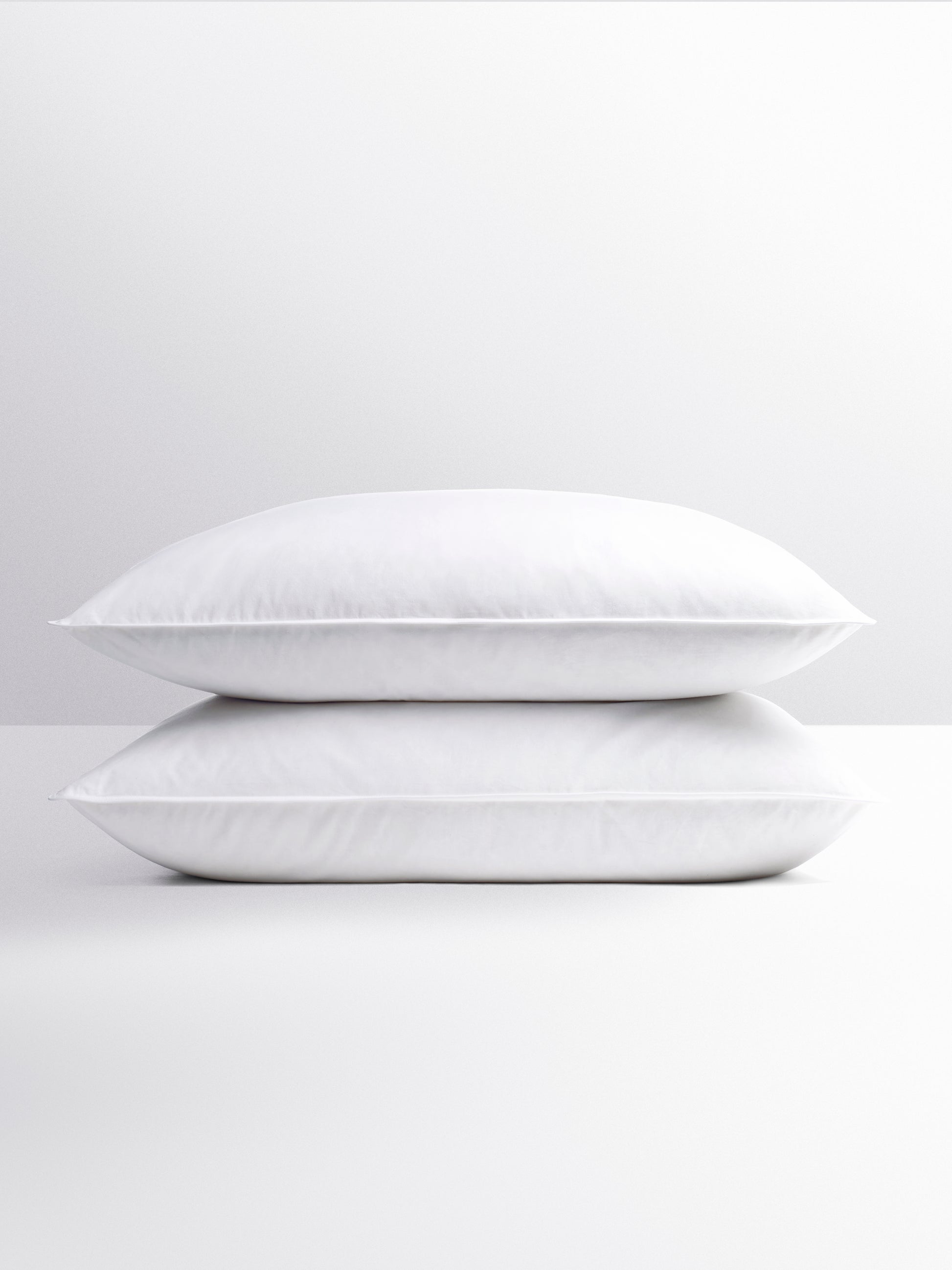 Two white pillows, designed to provide a peaceful and relaxing night's sleep.