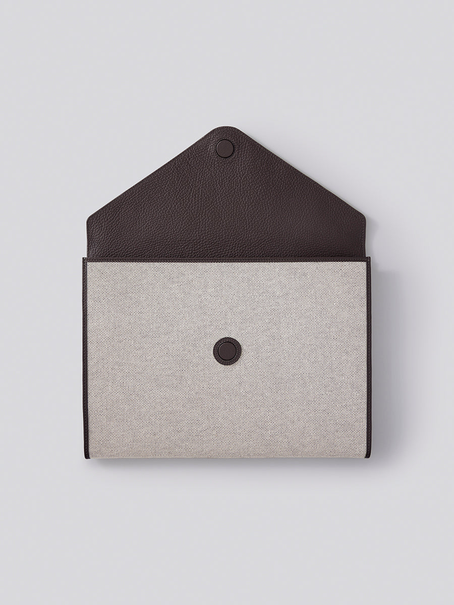 The Laptop Sleeve in Malaysian Cocoa, showcasing its protective interior and luxurious materials like Italian Pebble Grain Leather and Organic Cotton Toile. - {{Malaysian Cocoa}}