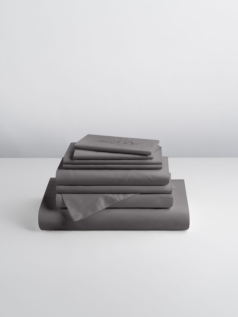 A set of Hampshire Charcoal-colored sheets, folded into perfect rectangles and stacked on a flat surface.