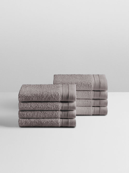 A stack of eight soft, “Hampshire Charcoal” colored bath wash clothes neatly folded on a white surface. - {{Hampshire Charcoal}}
