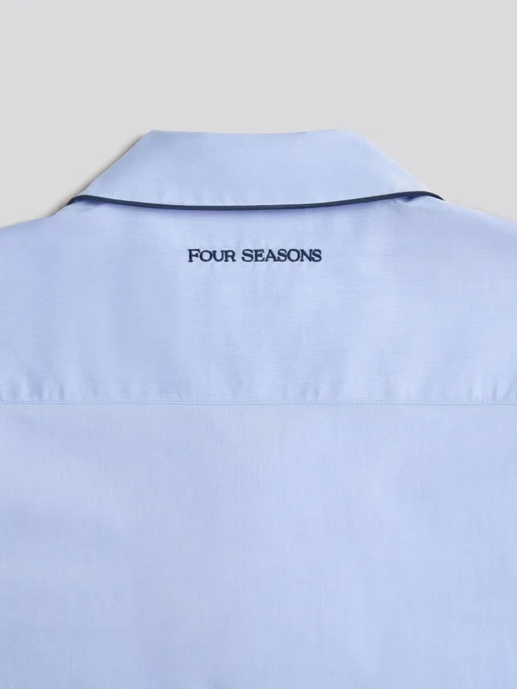 Light blue pajama shirt with 'FOUR SEASONS' text on the collar against a light gray background.