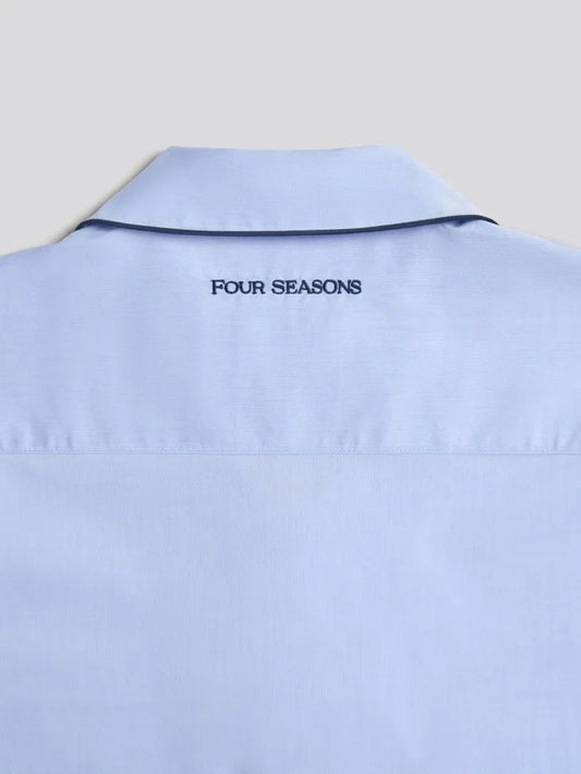 Light blue pajama shirt with 'FOUR SEASONS' text on the collar against a light gray background.