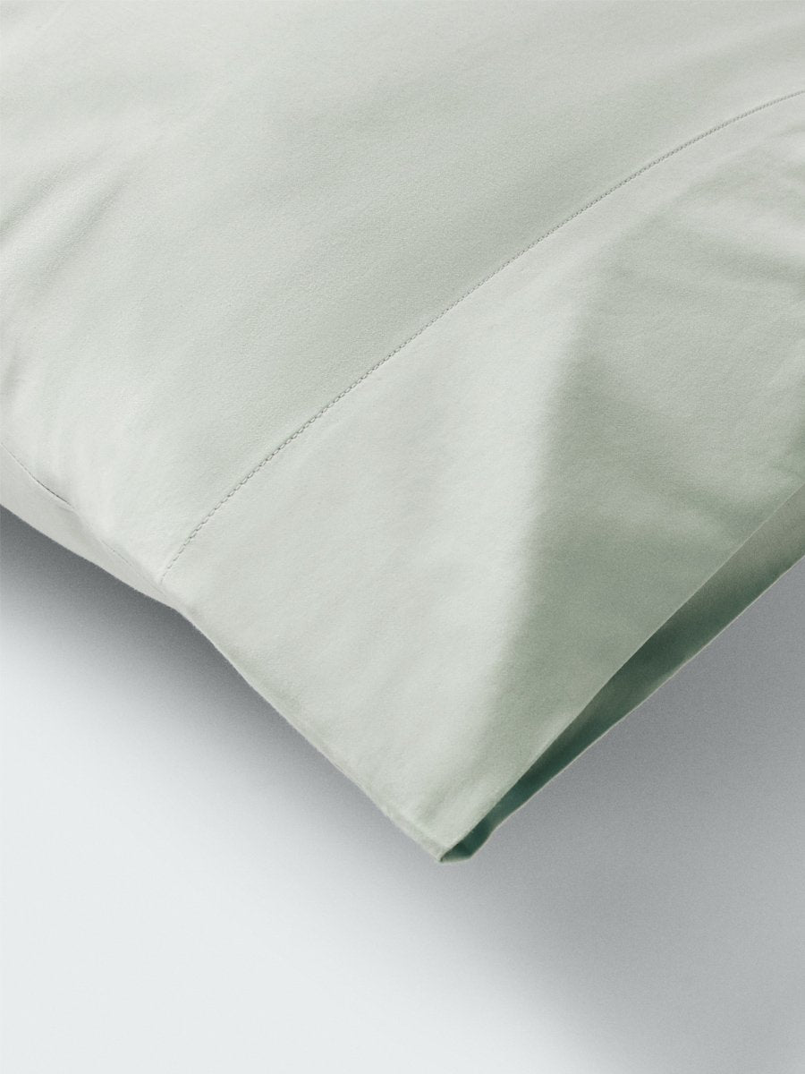 Part of a pillow with a pillowcase in Florentine Sage color. - {{Florentine Sage}}