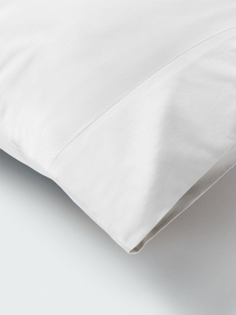 Part of a pillow with a pillowcase in Signature White color. - {{Signature White}}
