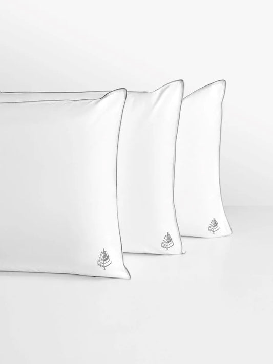 Three white pillows with the Four Seasons logo on a light gray background